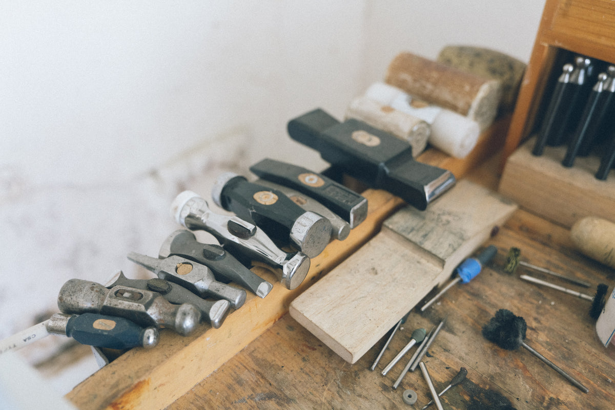 Jeweler’s hammers and metalworking tools arranged along a workbench in the Alexis Pavlantos studio