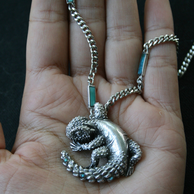 Sterling silver lizard pendant on thicks silver chain with turquoise inlay by New Mexico jeweler Alexis Pavlantos.
